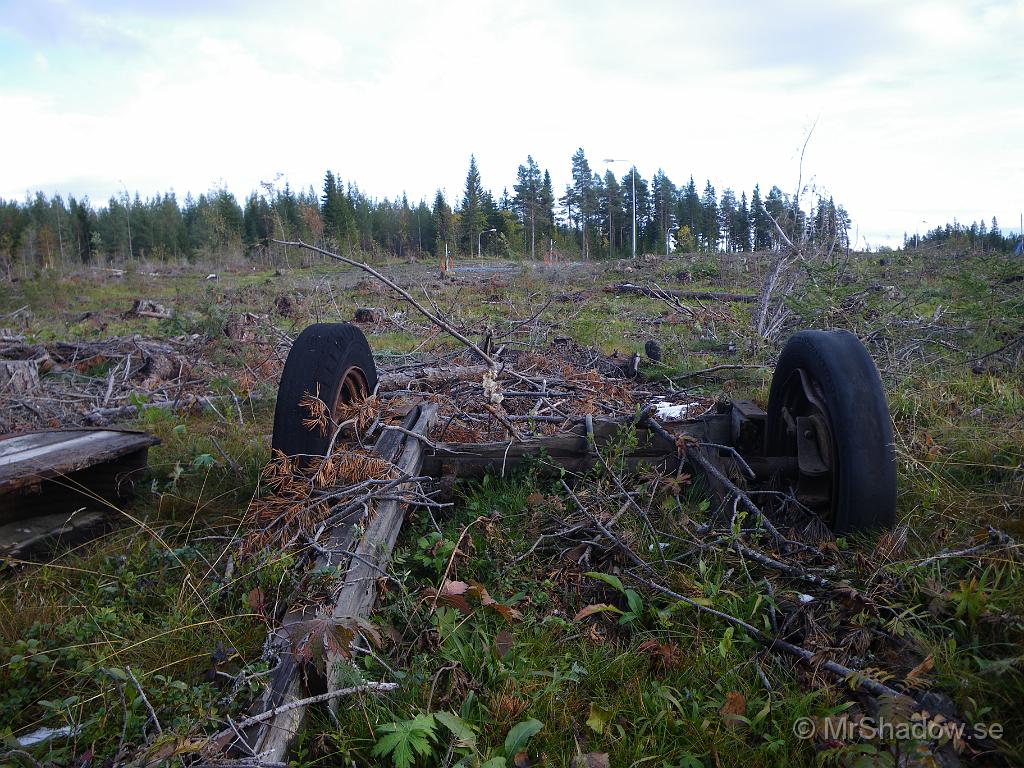 IMGP2139.JPG - Man bygger en gång och cykelväg i området och kärran är på ena sidan och resterna efter en annan vagn ligger på den andra.. En liten bit bort finns modernare "transportmedel". På stolpar som markerar villatomter, hänger orange fiberkabel.. Lite kontrast är det.