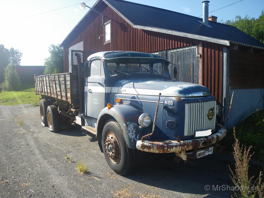 021x.jpg - Alldeles intill landsvägen är denna Volvo grusbil parkerad, just utanför ett typiskt åkargarage.Skulle inte tro att det garaget är speciellt välanvänt längre.