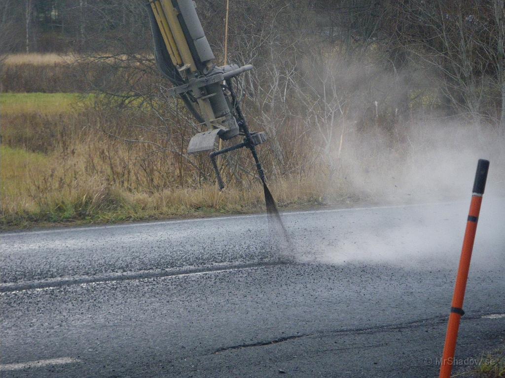 IMGP7601.JPG - Med lite tryck sprutas varm asfalt (Bitumen) ner i sprickorna och åtföljs av en kraftig dusch av fin singel..