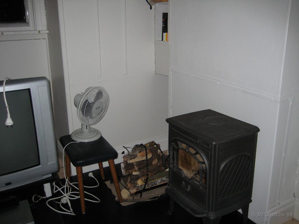 IX70_0228.JPG - Testat att köra en fläkt vid kaminen för att bättre sprida värmen.Det fungerade utmärkt, bara man stänger av den när luckan skall öppnas för mera ved..Annars så har man både aska och glöd ute på golvet