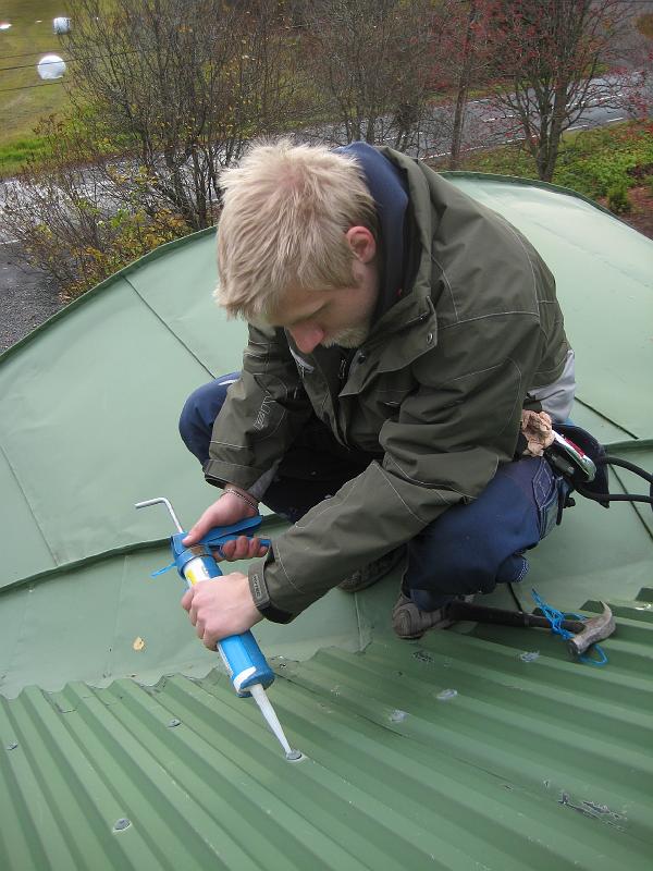 IX70_1865.JPG - Silikon pressas in mellan spikskalle och takplåt. Behövs det så får spiken lite massage av hammaren också